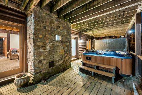 a bathroom with a tub in a stone wall at Luxurious Chalet! Hot-tub, Bonfire & Ideal Location for Skiing & Town in Ellicottville