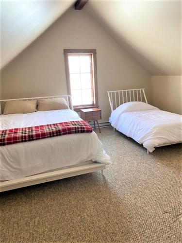 a bedroom with two beds and a window at Luxurious Chalet! Hot-tub, Bonfire & Ideal Location for Skiing & Town in Ellicottville