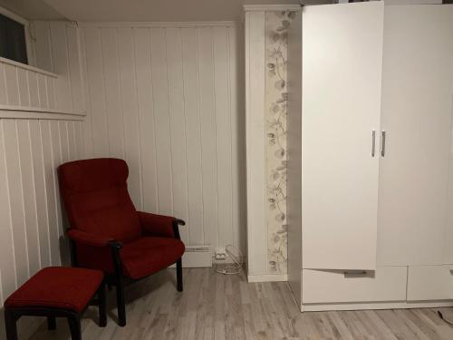 Habitación con silla roja y armario en Råstadveien 20 en Sandefjord