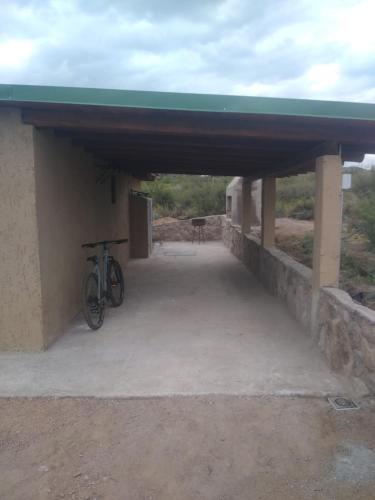 a bike parked under a building with a roof at Mulelle cabañas in Ciudad Lujan de Cuyo