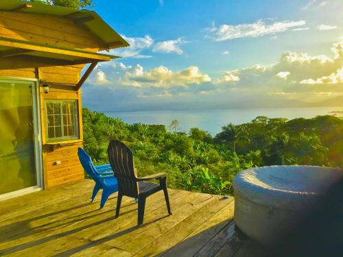 dwa krzesła na tarasie z widokiem na ocean w obiekcie MISTY MOONLIGHT VILLAS w mieście Bocas del Toro