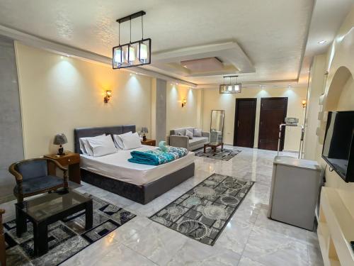 a bedroom with a bed and a couch and a tv at Grand Egyptian Museum View Inn in Cairo