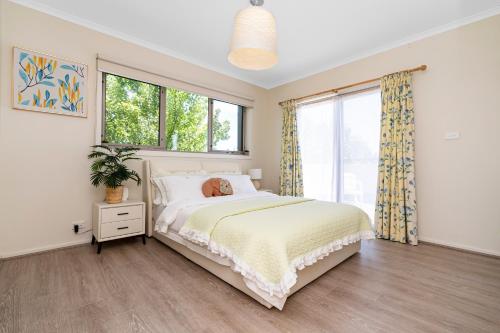 a bedroom with a bed and a large window at Stylish & Modern Townhouse in Canberra in Harrison