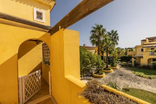 una casa gialla con cancello e cortile di La Casetta del Porticciolo a Pisticci