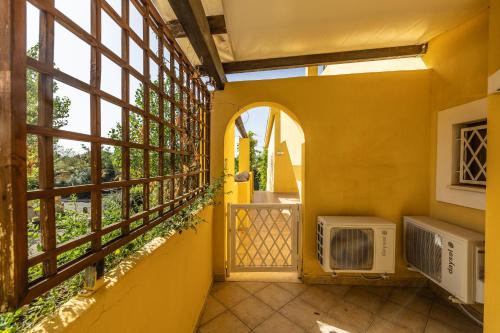 a yellow room with a window and an air conditioner at La Casetta del Porticciolo in Pisticci