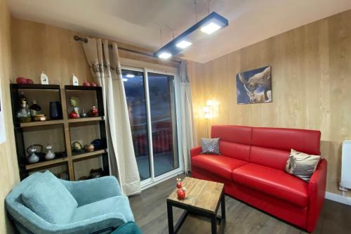 - un salon avec un canapé rouge et deux fauteuils bleus dans l'établissement Ski in and ski out apartment Superdévoluy, à Saint-Étienne-en-Dévoluy