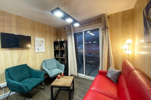 - un salon avec un canapé rouge et deux fauteuils bleus dans l'établissement Ski in and ski out apartment Superdévoluy, à Saint-Étienne-en-Dévoluy