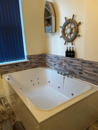 El baño incluye una bañera grande con ruedas. en The Buxton Retreat A Luxurious 3-Storey Townhouse with Four Poster Bed and Double Jacuzzi Bath", en Buxton