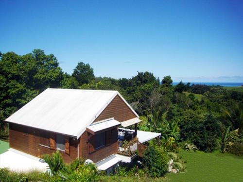 ein Haus mit weißem Dach auf einem Feld in der Unterkunft Location Mont Sofa in Sainte-Rose
