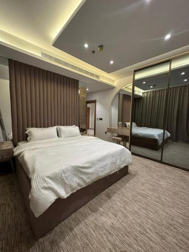 um quarto grande com uma cama grande e um espelho em شقة فاخرة في برج جلامور em Riyadh