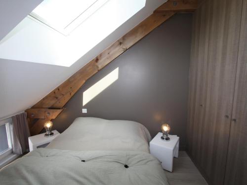 - une chambre mansardée avec un lit et 2 tables de nuit dans l'établissement Appartement neuf et lumineux à Gérardmer, proche du lac - FR-1-589-88, à Gérardmer