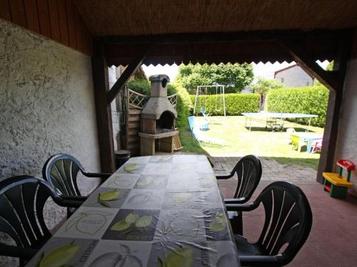 - une table, des chaises et une aire de jeux dans l'établissement Gîte spacieux avec terrasse, 3 chambres, équipements bébé, à 16 km de Gérardmer - FR-1-589-23, à Aumontzey
