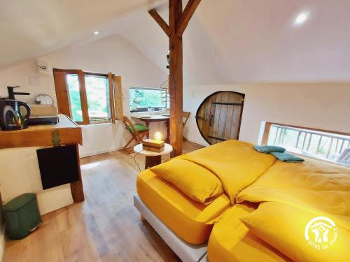 sypialnia z dużym żółtym łóżkiem w pokoju w obiekcie Gîte Montenay, 2 pièces, 2 personnes - FR-1-600-220 w mieście Montenay