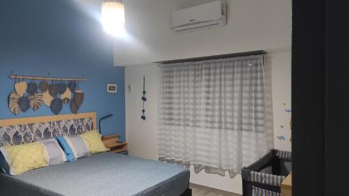 una camera con letto e finestra con tenda di Casa a 21 minutos de aeropuerto de Ezeiza tranfer opcional amplio parque para mascotas a Ezeiza