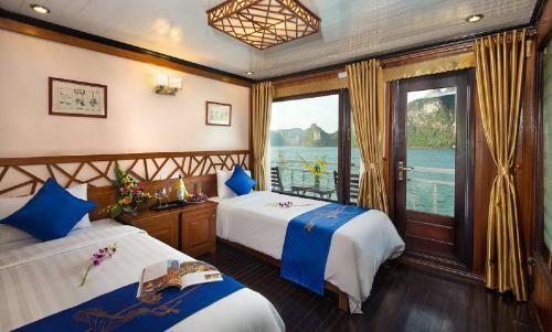 2 camas en una habitación con vistas al agua en Royal Palace Cruise en Ha Long