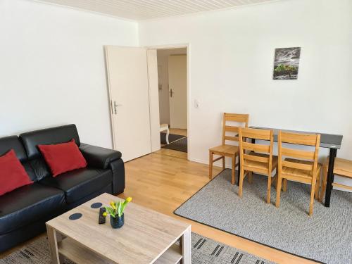 ein Wohnzimmer mit einem Sofa und einem Tisch in der Unterkunft Apartments bei Marienplatz in Stuttgart