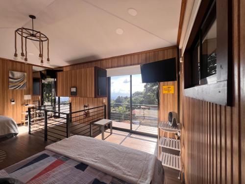 a bedroom with a bed and a view of a balcony at Villazul 2 in Poás