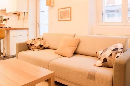 uma sala de estar com um sofá e uma mesa em Cosy 38 m love nest near Centquatre-Paris em Paris