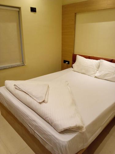 Gauripur的住宿－Hotel Skyking，一张带白色床单和枕头的床