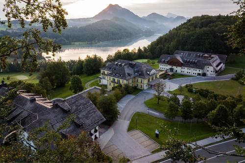 an aerial view of a village with a lake and mountains at Arabella Jagdhof Resort am Fuschlsee, a Tribute Portfolio Hotel in Hof bei Salzburg