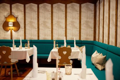 a dining room with two tables with candles on them at Arabella Jagdhof Resort am Fuschlsee, a Tribute Portfolio Hotel in Hof bei Salzburg