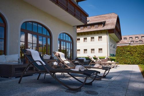 a group of chairs sitting on a patio at Arabella Jagdhof Resort am Fuschlsee, a Tribute Portfolio Hotel in Hof bei Salzburg