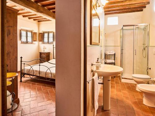 baño con lavabo y 1 cama en una habitación en Beautiful farmhouse with swimming pool in Tuscany en Cavriglia