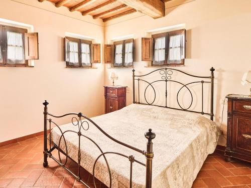 1 dormitorio con cama negra y ventanas en Beautiful farmhouse with swimming pool in Tuscany, en Cavriglia