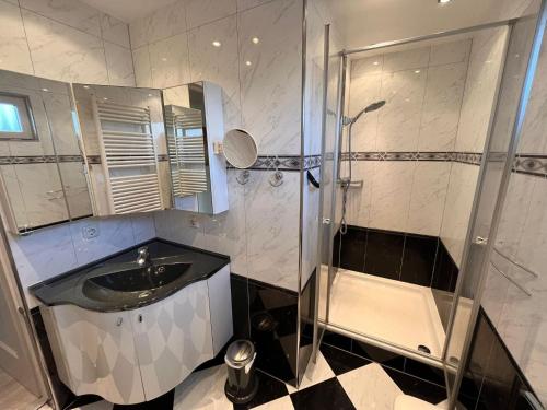 een badkamer met een douche en een wastafel bij Spacious bungalow with roofed terrace 
