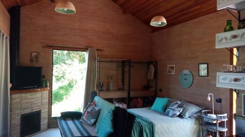 1 dormitorio con cama y ventana en Sonho na Serra Chalé 2 en Gonçalves