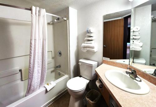 a bathroom with a white toilet and a sink at Super 8 by Wyndham Austin North/University Area in Austin