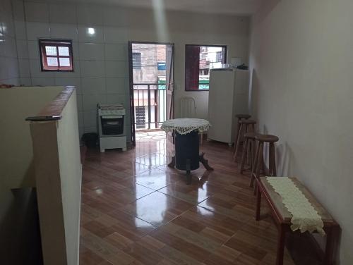 Habitación con cocina con mesa y sillas. en kitnet sao thome das letras, en São Thomé das Letras