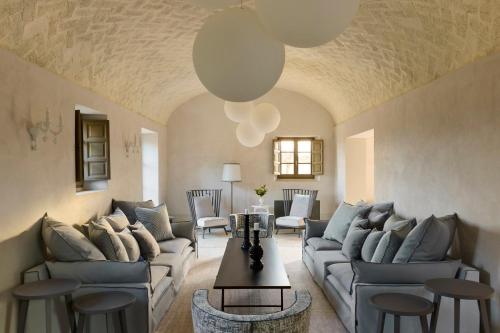 a living room with couches and a table at COMO Castello Del Nero in Tavarnelle in Val di Pesa