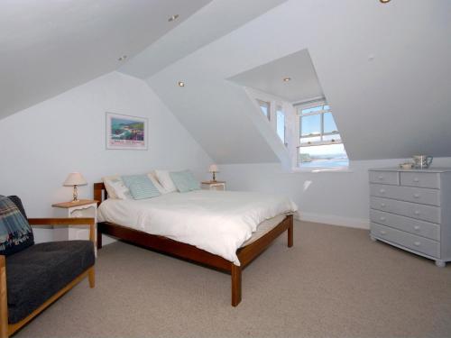 a bedroom with a bed and a dresser and a window at Ty Mair in Tenby