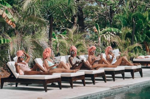 un grupo de mujeres sentadas en tumbonas junto a una piscina en Villa Coco en Santa Catalina