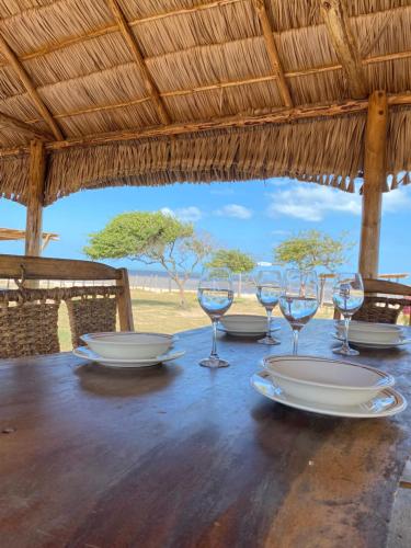 a table with plates and wine glasses on it at Guajira Beach in Ríohacha