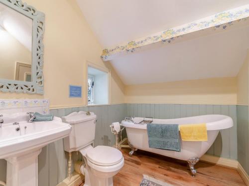 a bathroom with a tub and a toilet and a sink at Riverside Cottage 