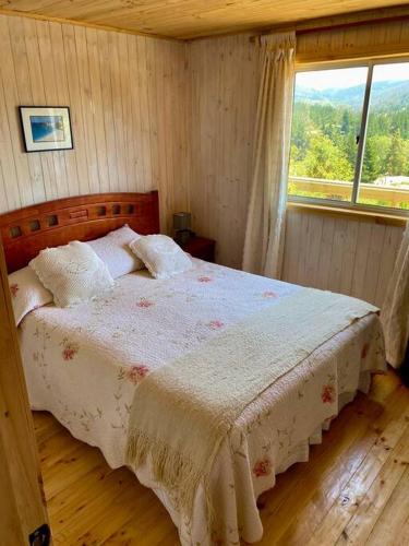 1 dormitorio con 1 cama y ventana grande en Cabaña en Vichuquén, Chile, en Vichuquén