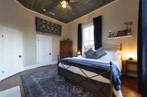 a bedroom with a bed and a window and a ceiling at The Cahill- Magnolia Brewery House c 1894 in Waco