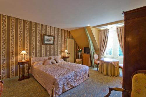 a bedroom with a bed in a room with wallpaper at Château de la Verie in Challans