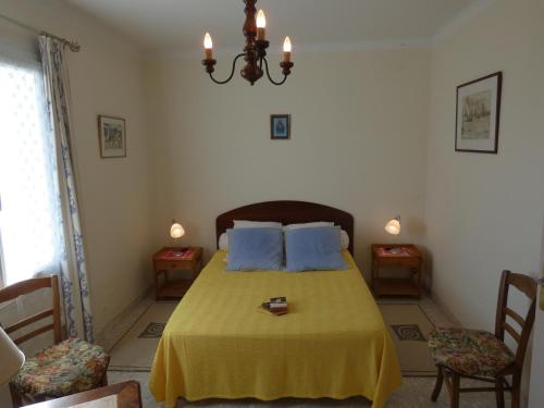 1 dormitorio con 1 cama con almohadas azules y 2 sillas en Maison Notre-Dame-de-Monts, 3 pièces, 4 personnes - FR-1-540-248, en Notre-Dame-de-Monts