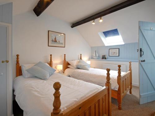 two twin beds in a bedroom with a skylight at Ty Gwyn Farmhouse in St. Davids