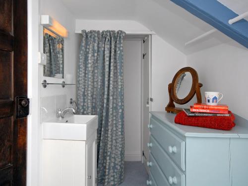 a bathroom with a sink and a shower curtain at Ty Gwyn Farmhouse in St. Davids