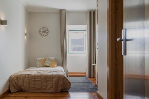 a bedroom with a bed and a clock on the wall at Hotel Casa da Nora in Leiria
