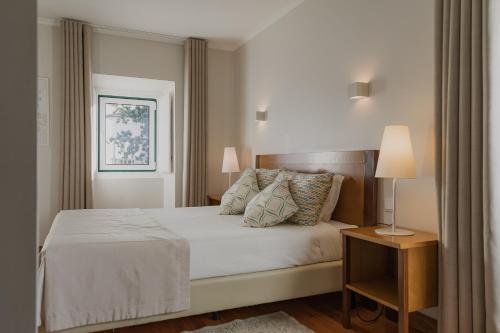 a bedroom with a bed and a window at Hotel Casa da Nora in Leiria