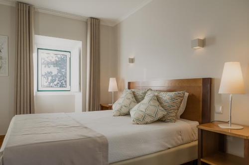a bedroom with a large bed with two pillows at Hotel Casa da Nora in Leiria