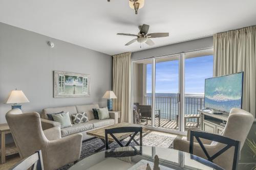a living room with a couch and a tv at Majestic Sun Resort by Tufan in Destin