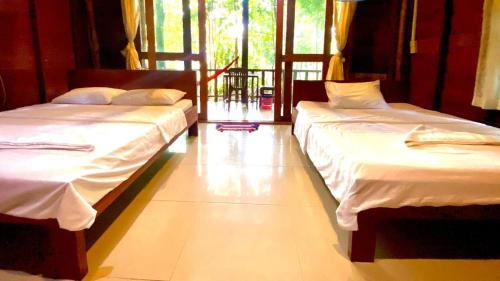 two beds sitting in a room with at Sambath Sakseth Bungalow in Koh Rong Island
