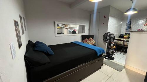 1 dormitorio con cama negra y espejo en Hospedagem Recanto da Praia Posto 12, en Río de Janeiro