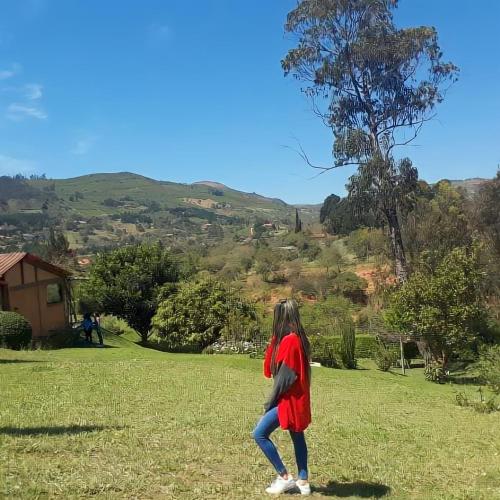 Una mujer parada en un campo con una cometa en Cabañas Lijeron Samaipata, en Samaipata